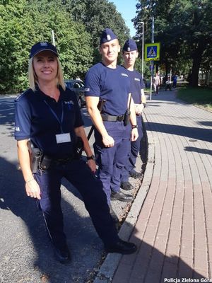 Trójka policjantów stoi na chodniku.