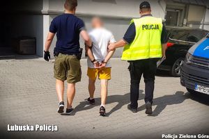 Dwójka policjantów odprowadza podejrzanego.