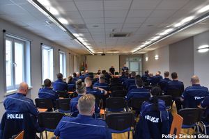 Grupa policjantów siedząca w sali konferencyjnej.