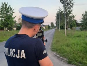 Zbliżenie na policjanta który mierzy prędkość nadjeżdżających samochodów