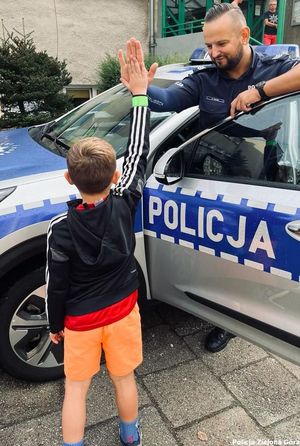 Policjant zbija piątkę z chłopcem.
