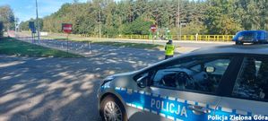 Funkcjonariusz policji mierzący prędkość nadjeżdżających samochodów.