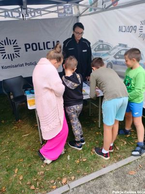 Policjantka rozmawia z dziećmi przy policyjnym stoisku