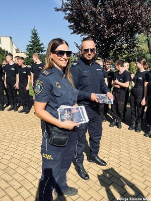 Policjant i funkcjonariuszka straży miejskiej rozdają ulotki zostań zielonogórskim policjantem