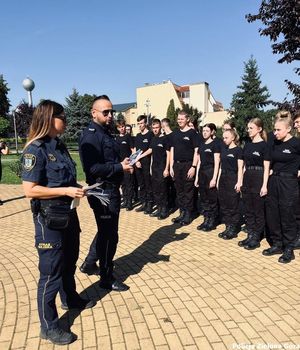 Policjant i funkcjonariuszka straży miejskiej rozdają ulotki zostań zielonogórskim policjantem