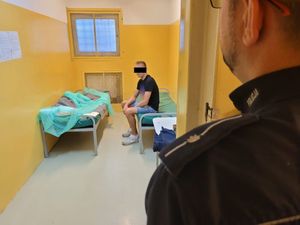 Policjant pilnuje zatrzymanego mężczyznę