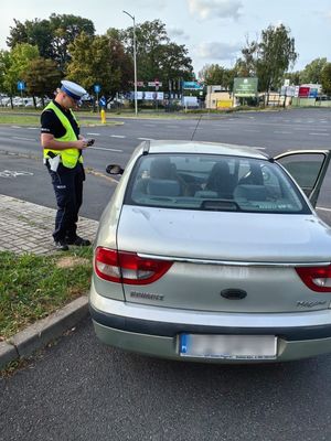 Policjant Ruchu Drogowego kontroluje kierowcę samochodu marki Renault