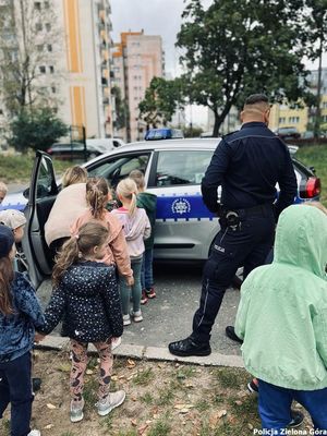 Policjant pokazuje dzieciom radiowóz