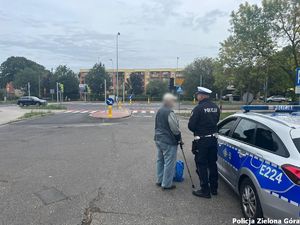 Policjant Ruchu Drogowego pilnuje bezpieczeństwa na jednej z dróg w Zielonej Górze i rozmawia ze starszym panem