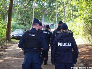 sześciu policjantów idzie w kierunku stadionu żużlowego