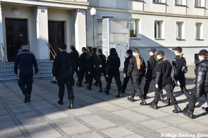 Policjant oprowadza uczniów klasy policyjnej po terenie Komendy Miejskiej Policji w Zielonej Górze