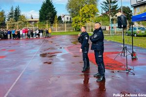 Dwóch policjantów rozmawia z młodzieżą na boisku Zespołu Szkół Technicznych w Zielonej Górze