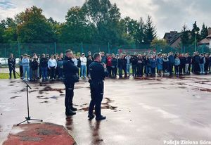 Dwóch policjantów rozmawia z młodzieżą na boisku Zespołu Szkół Technicznych w Zielonej Górze