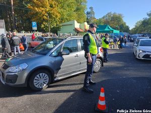 Dwóch strażników miejskich pilnuje porządku na terenie parkingu cmentarza komunalnego w Zielonej Górze