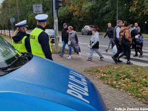 Dwóch policjantów Ruchu drogowego obserwuje przejście dla pieszych przy cmentarzu na ulicy Wrocławskiej