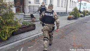 Dwóch uzbrojonych policjantów i i pies policyjny wchodzą do budynku