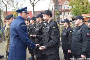 Zastępca komendanta komisarz Krzysztof Marciniak wręcza uczniowi symboliczne pagony kadetów klasy mundurowej i gratuluje