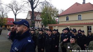 Policjant i uczniowie klasy policyjnej podczas odśpiewania hymnu