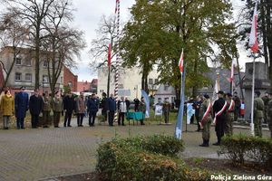 Poczet sztandarowy oraz osoby ze służb i instytucji przed pomnikiem pamięci