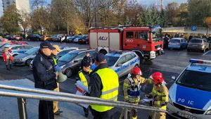 Policjanci z wydziału Sztab Policji i strażacy stoją przed komendą