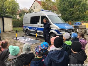 Policjantka przy radiowozie z dziećmi