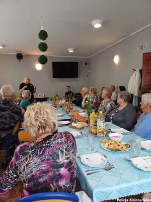 Policjantka rozmawia z seniorami.