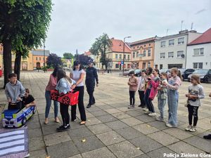 Panie pomagają założyć dziewczynce przebranie samochodu.