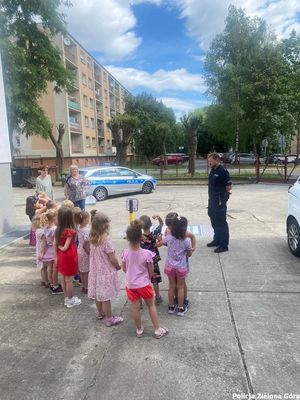 Policjant tłumaczy dzieciom jak być bezpiecznym w trakcie wakacji.