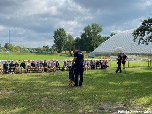 Policjant tłumaczy dzieciom do czego służy pies policyjny.