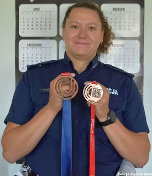 Policjantka pozująca z dwoma brązowymi medalami.