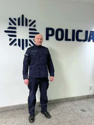na zdjęciu widzimy policjanta w granatowym mundurze służbowym, w tle napis POLICJA