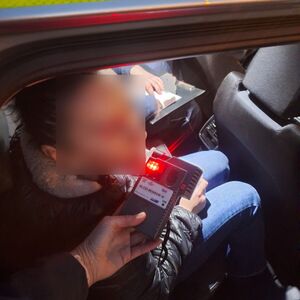 policjant bada kierowcę na zawartość alkoholu